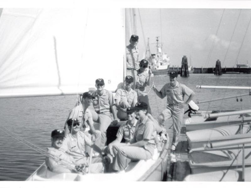 The graduates of BOTC 45 are seated in a small boat alongside a dock.