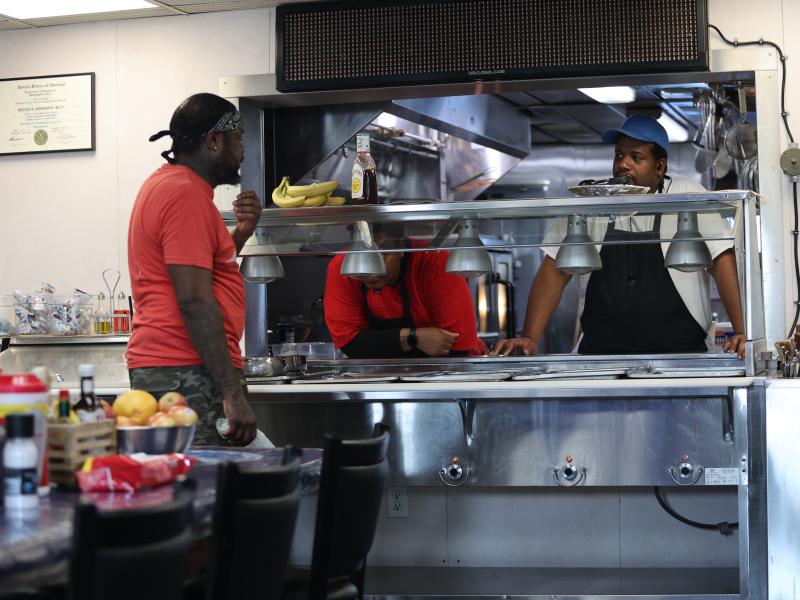 A steward talks with fellow crew member during meal service aboard a NOAA ship