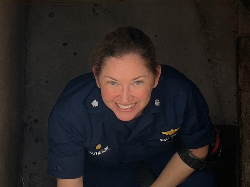 A female NOAA Corps officer in a stairwell aboard a ship