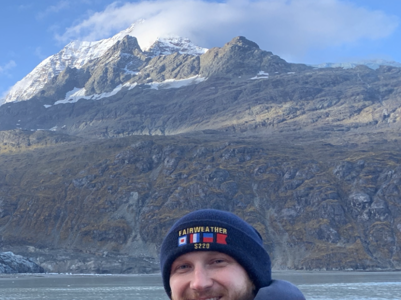 Sean Battles in a small boat in front of Mount Fairweather