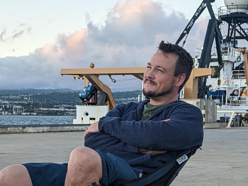 Mariner Jason Dlugos enjoying the sunset on the dock in front of NOAA Ship Oscar Elton Sette.