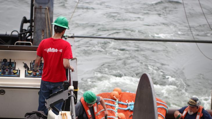 A NOAA ship crew member operating a system that deploys and recovers a net