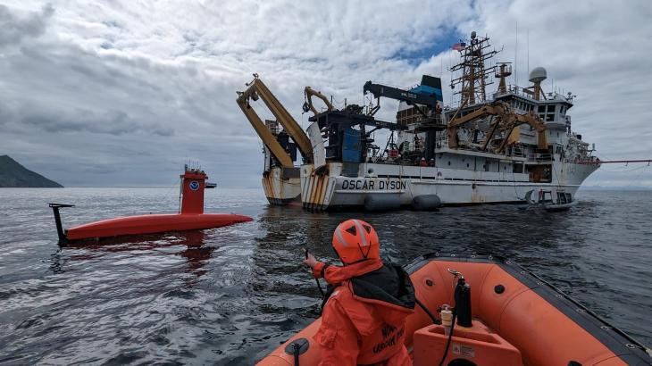 An uncrewed surface vehicle behind NOAA Ship Oscar Dyson