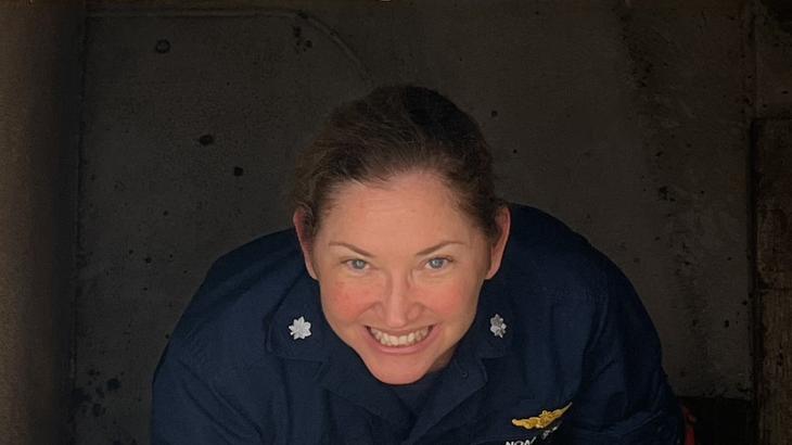 A female NOAA Corps officer in a stairwell aboard a ship