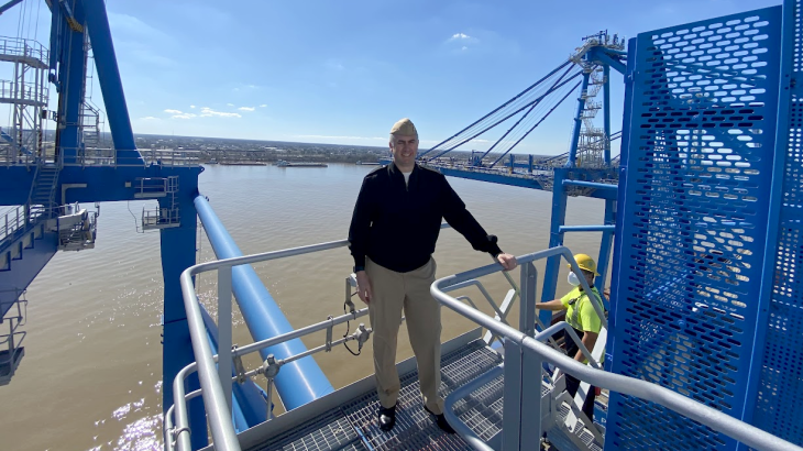 RDML Ben Evans stands atop a structure over the water.