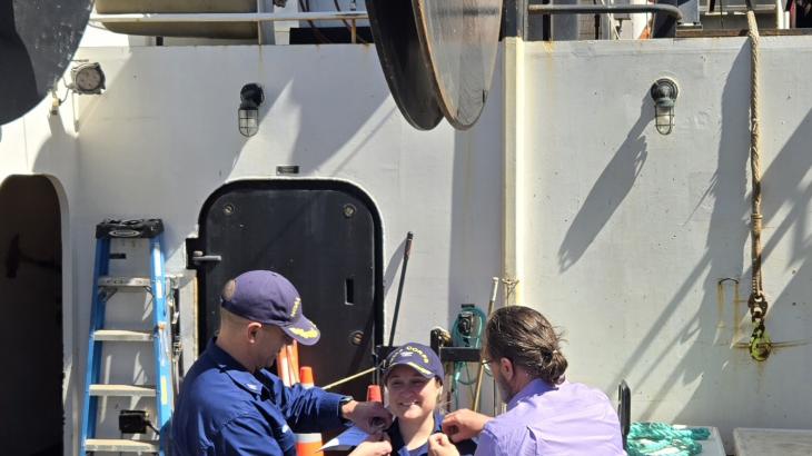 Rear Adm. Amanda Goeller receiving her new pins during her promotion ceremony aboard NOAA Ship Bell M. Shimada