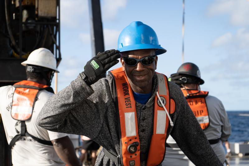 Derrick Mitchell salutes the camera while working on deck