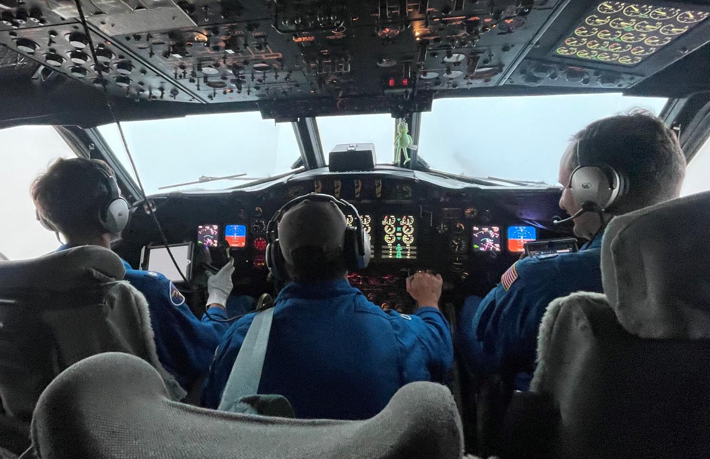 Pilots and flight engineer at the controls of NOAA WP-3D Orion N42RF during flight into Hurricane Ian