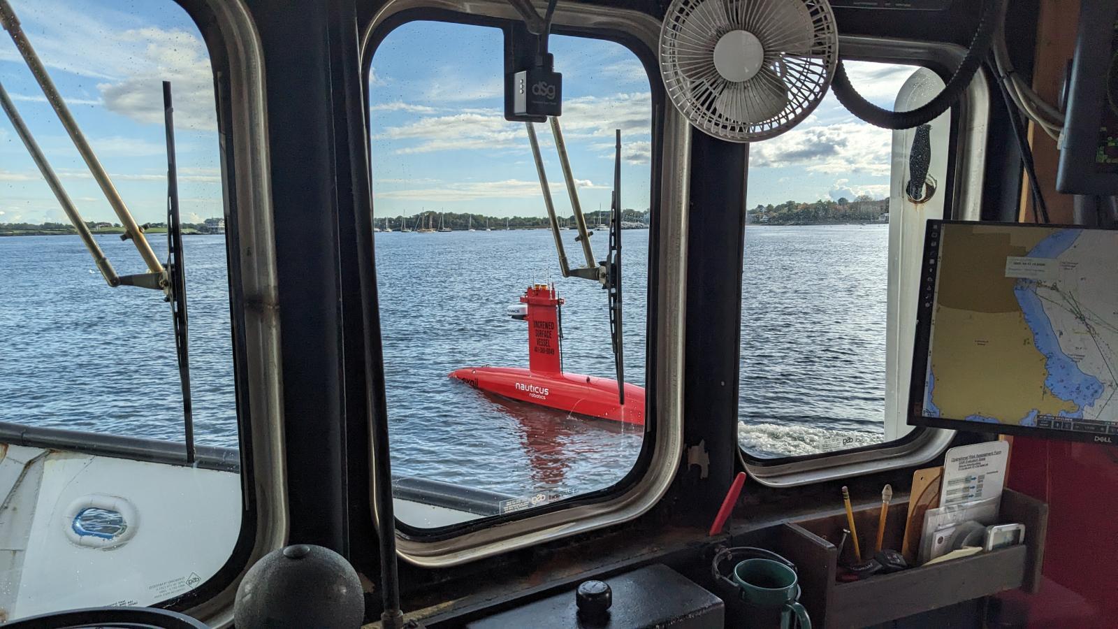 DriX uncrewed surface vehicle seen through a vessel window