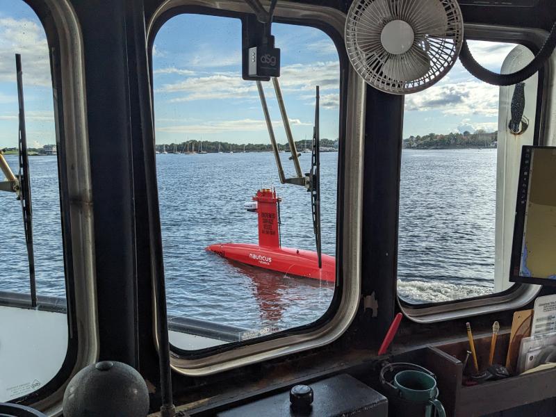 DriX uncrewed surface vehicle seen through a vessel window