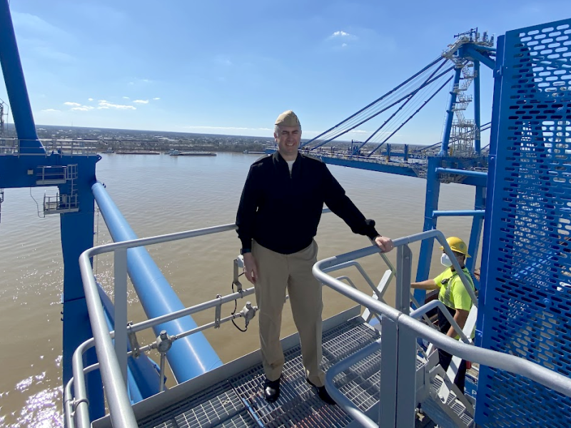 RDML Ben Evans stands atop a structure over the water.