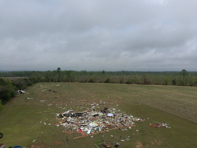 A birds eye view of damage following a tornado. The structure was completely destroyed with debris blown downstream.