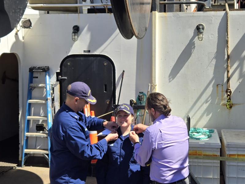 Rear Adm. Amanda Goeller receiving her new pins during her promotion ceremony aboard NOAA Ship Bell M. Shimada