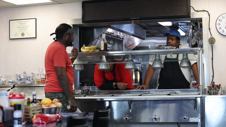 A steward talks with fellow crew member during meal service aboard a NOAA ship