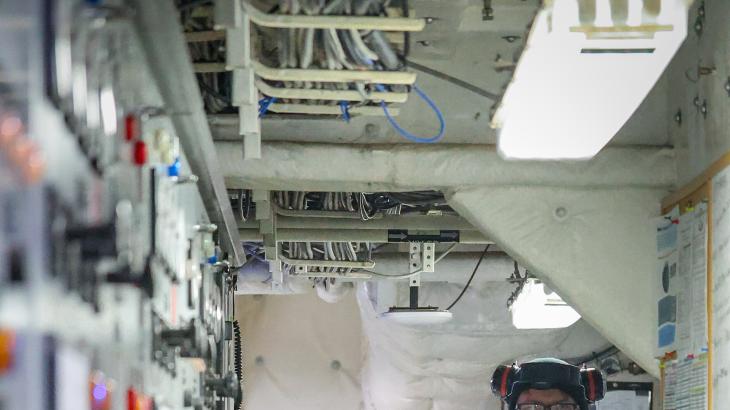 An engineer stands in the engineering operating space aboard a NOAA ship