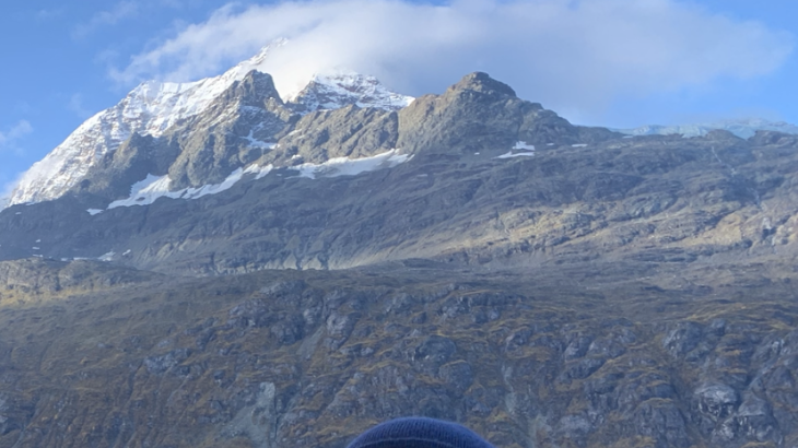 Sean Battles in a small boat in front of Mount Fairweather