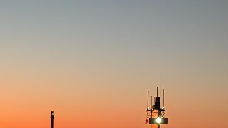 A red DriX uncrewed surface vehicle sails into the sunset