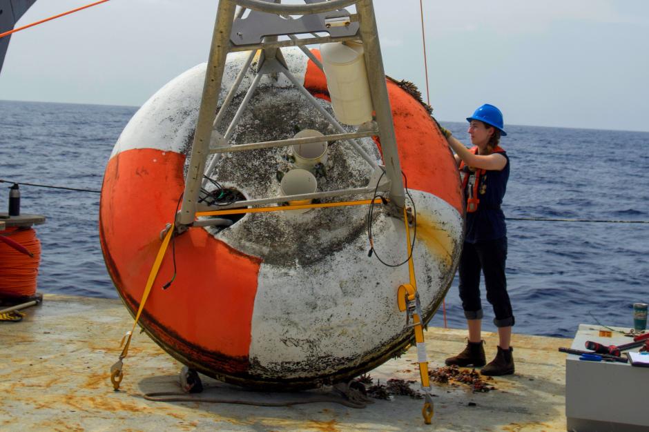 A crew member works on a bouy on the deck of a ship