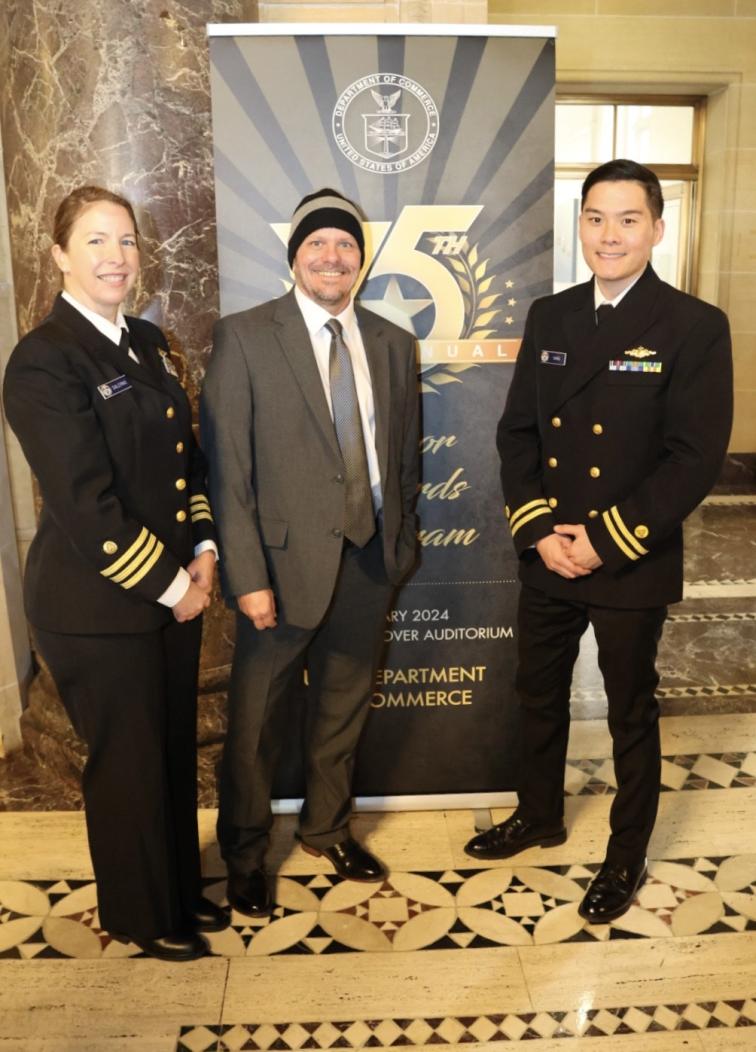 Three people standing in front of a banner